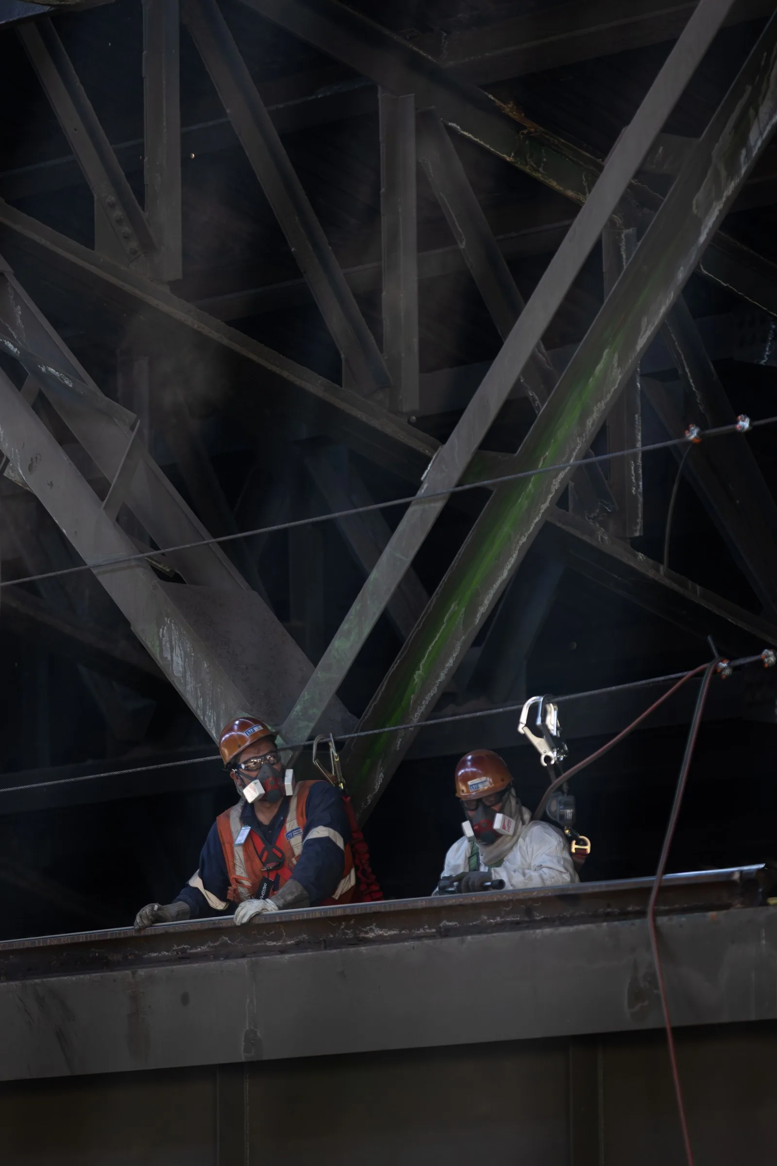 Dos trabajadores sobre la viga de la nave