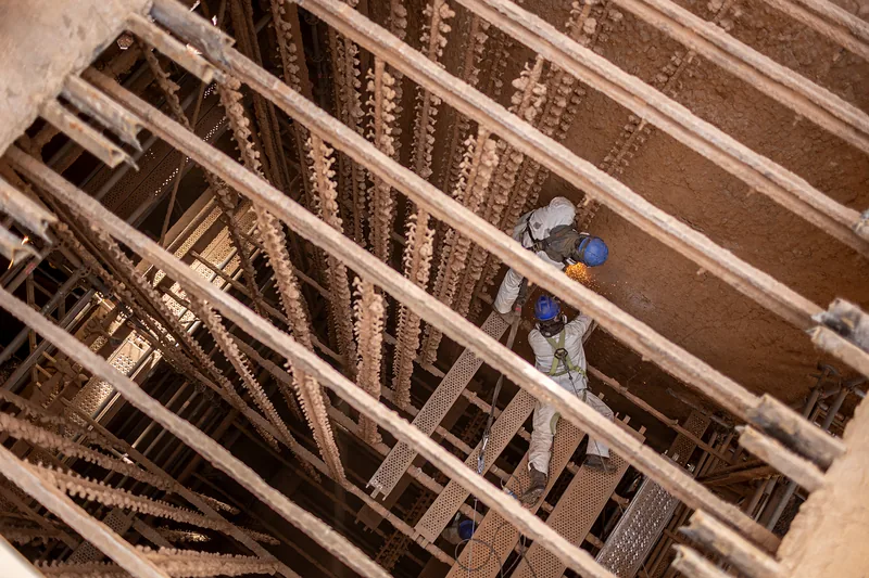 Trabajador entre las estructuras internas del precipitador