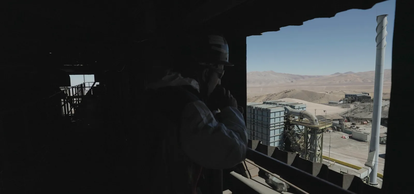 LTF worker looking at the smelter from a plant window